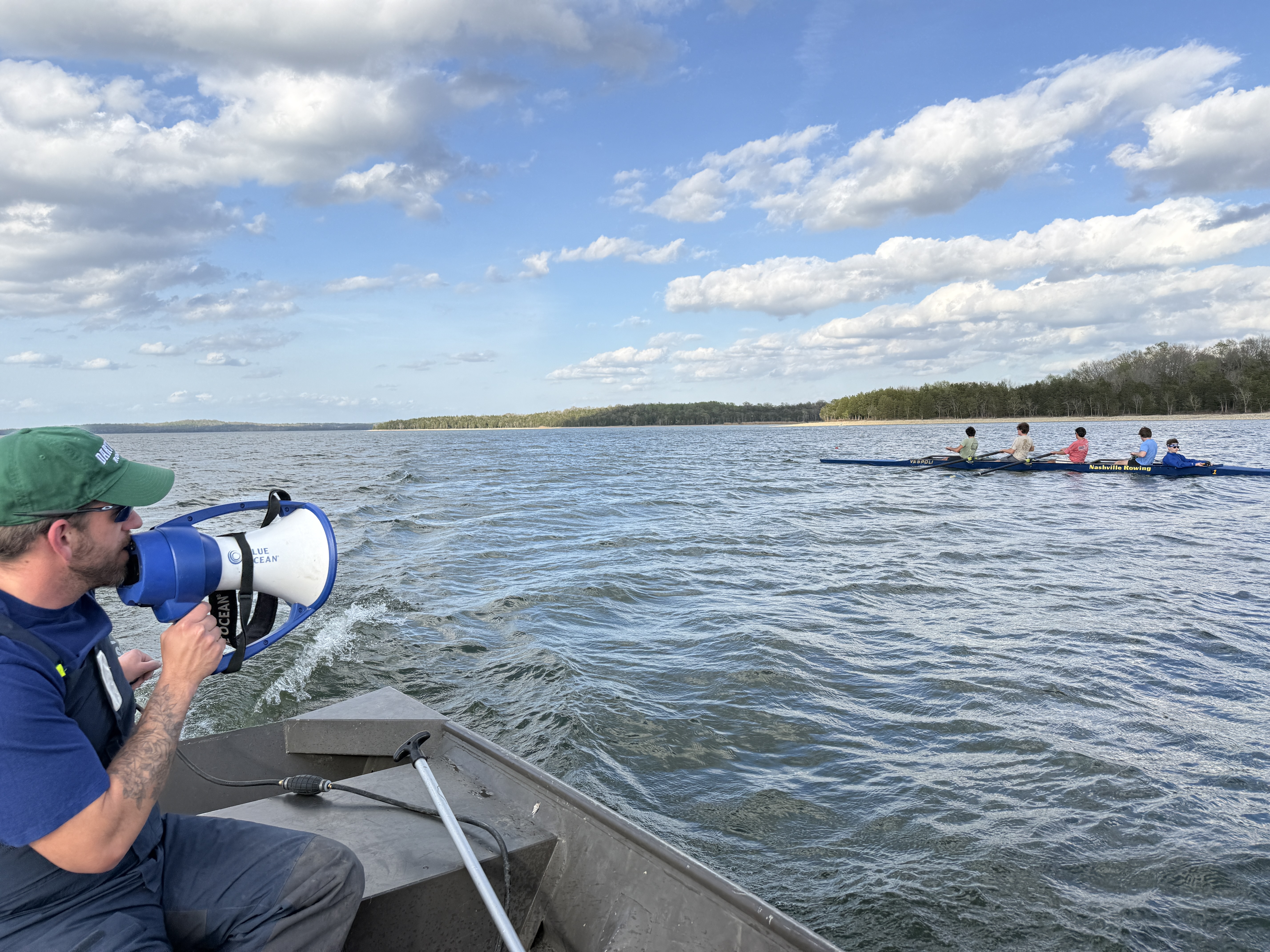 Daniel coaching a mens coxed four from the launch in the afternoon on Percy Priest Lake